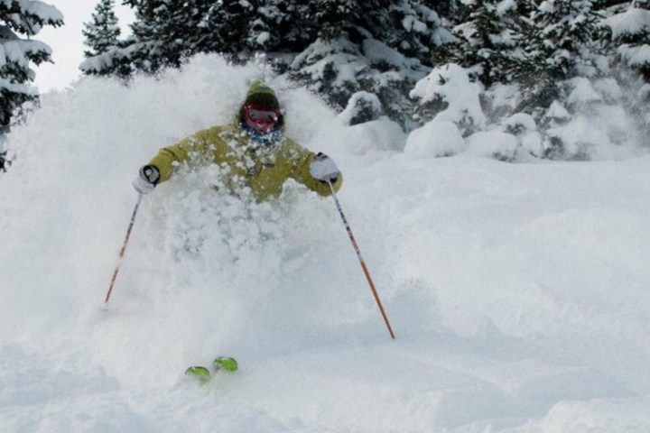 a man riding skis down a snow covered slope