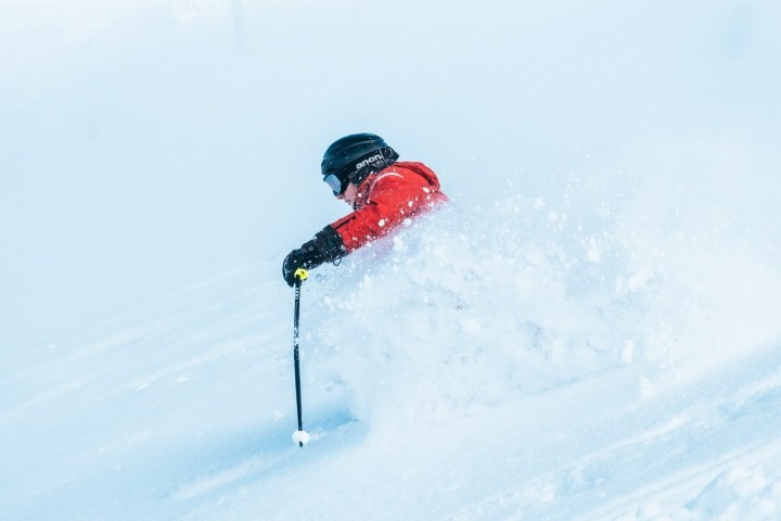 a man riding skis down a snow covered slope
