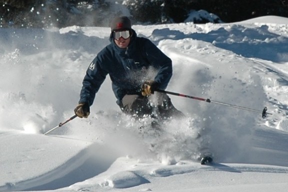 a man riding skis down a snow covered slope
