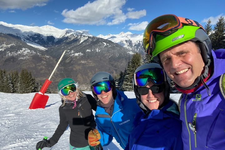 a group of people standing on top of a snow covered slope