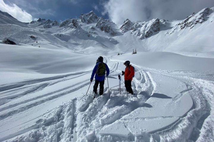 a man riding skis down a snow covered mountain