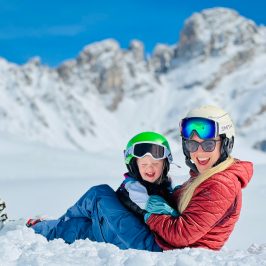 a person riding a snowboard down a snow covered mountain